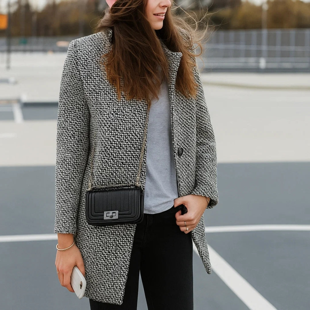 Venetia long wool coat in black and white, three-quarter view with shoulder bag