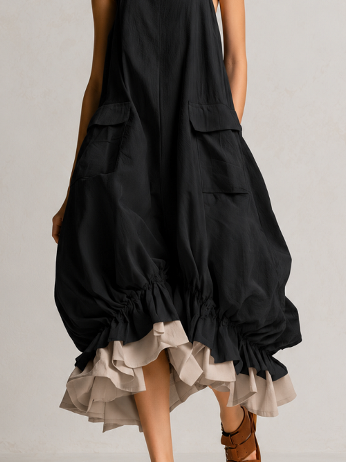 Dorothea layered balloon midi dress in black, close-up of flap pockets and ruffle hem