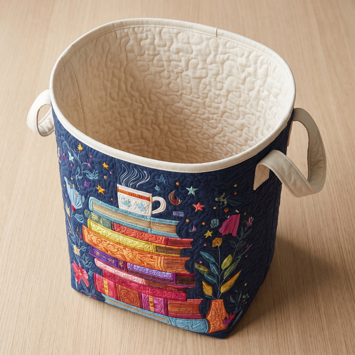 Ludovica hand-quilted laundry basket with a colourful stack of books and a teacup, open empty view