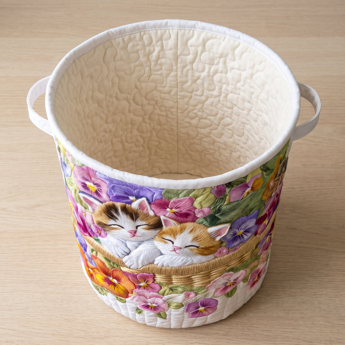 Sara hand-quilted laundry basket with two sleeping kittens among pansies, interior view