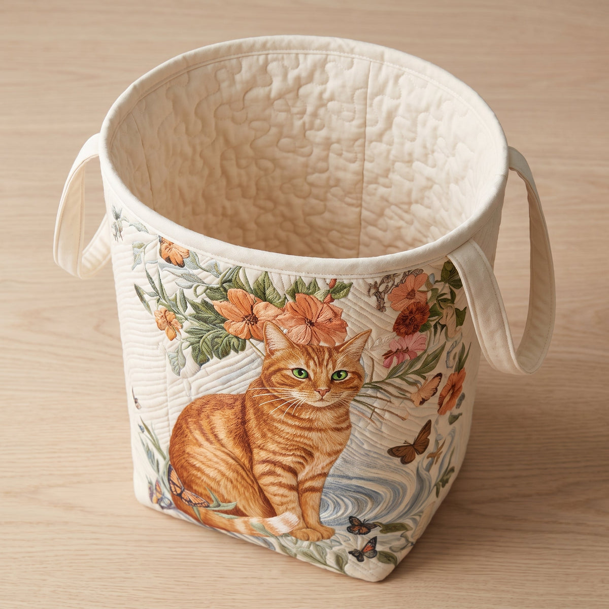 Matilda hand-quilted laundry basket with a ginger tabby cat and orange blossoms, top view showing the quilted lining