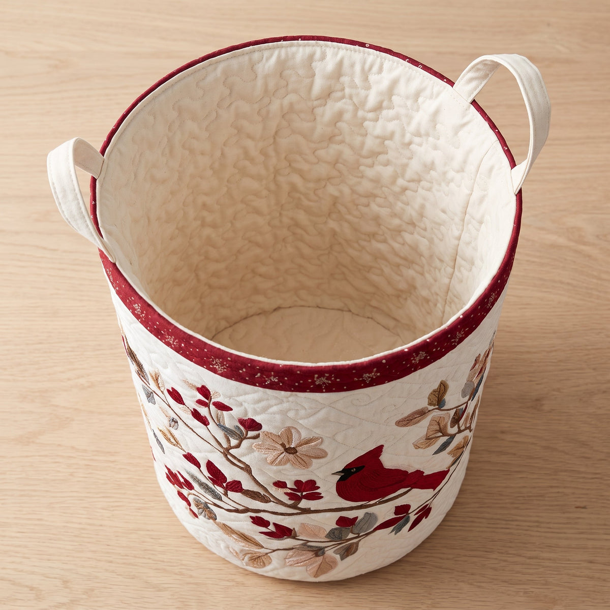 Lucia hand-quilted laundry basket with a red cardinal on a blossoming branch, open empty view