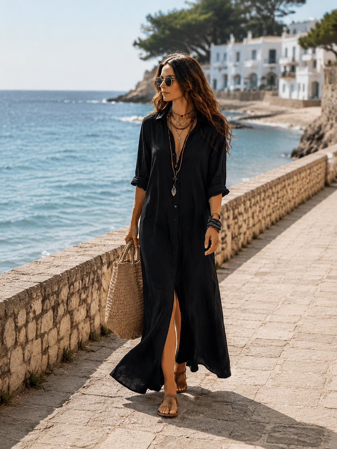 Marian long linen-look shirt dress in black, walking along a seaside promenade