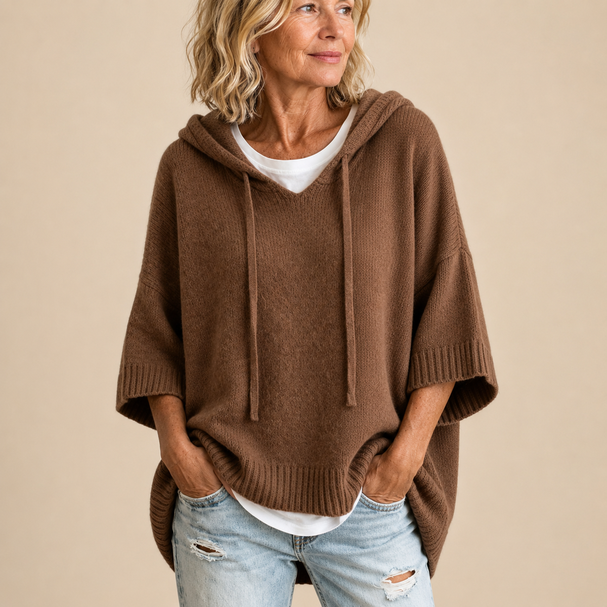 Hooded knit poncho in brown, front view with face