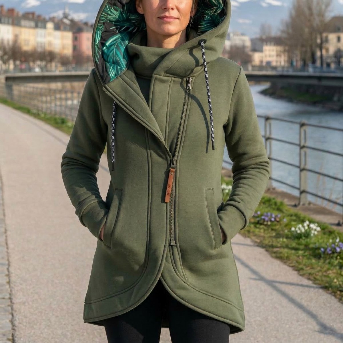 Letitia warm hooded jacket in olive green, front view by a river