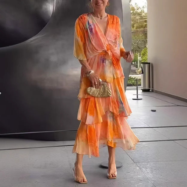 Lettice floral tiered wrap dress in orange, worn with gold clutch