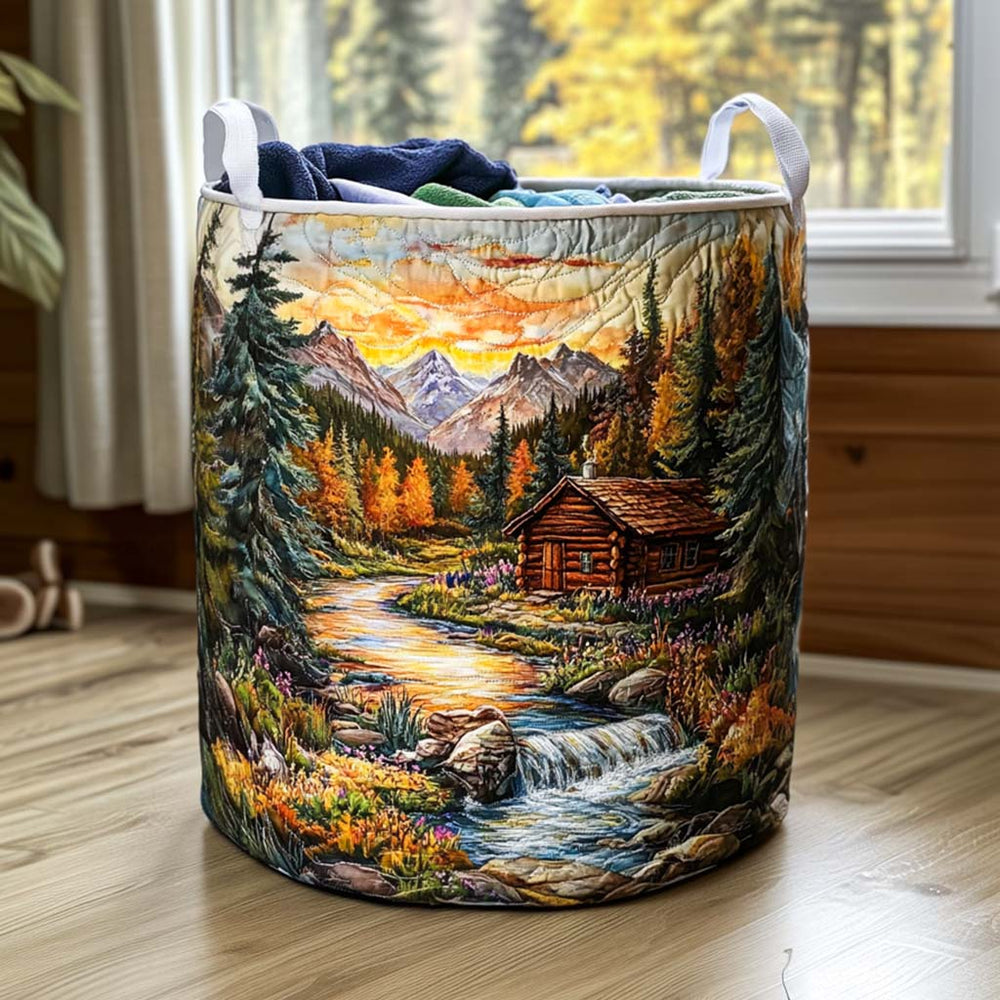 Renata hand-quilted laundry basket with a log cabin beside a river at sunset, front view by a window