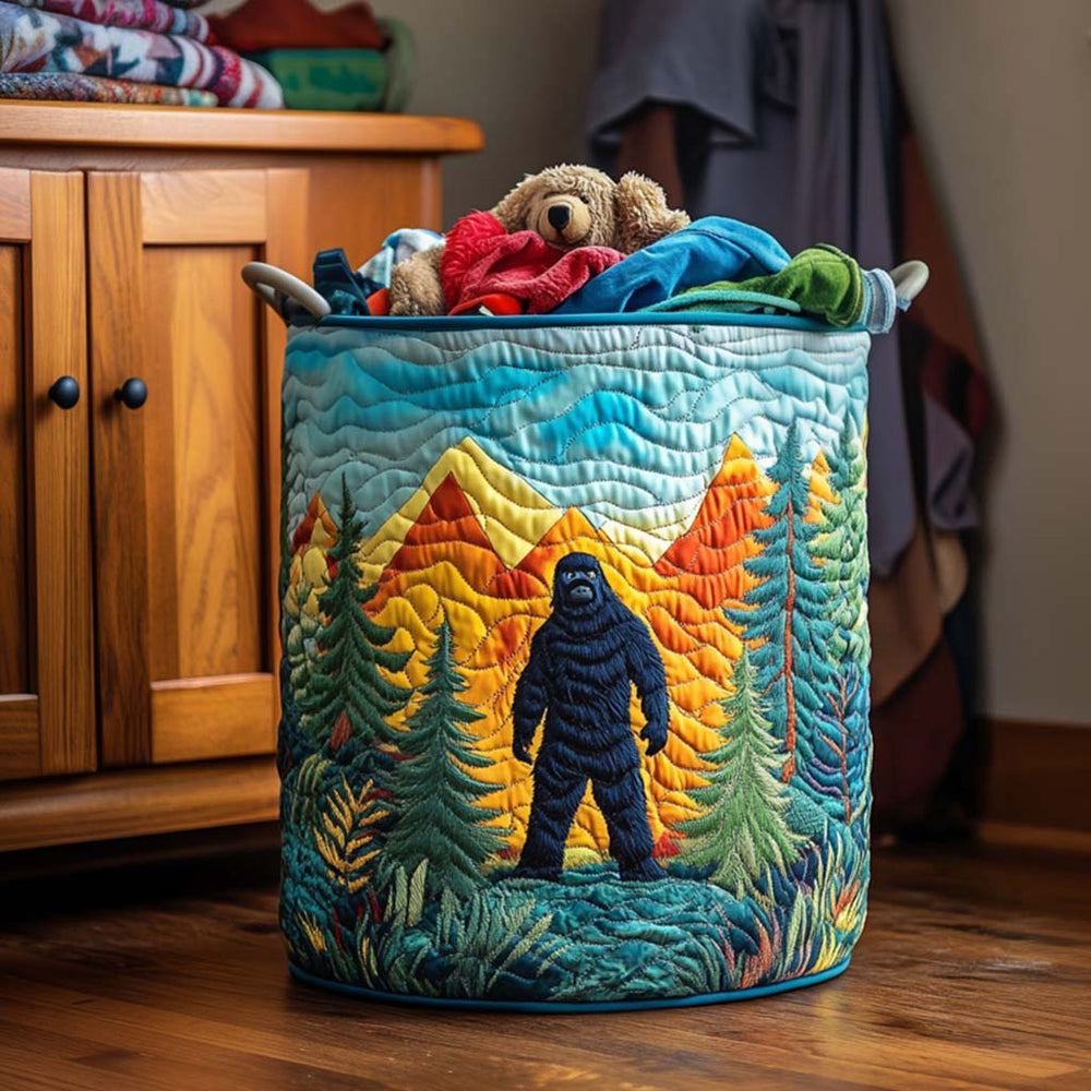 Rita hand-quilted laundry basket with a Sasquatch among pine trees and golden mountains, front view in a bedroom
