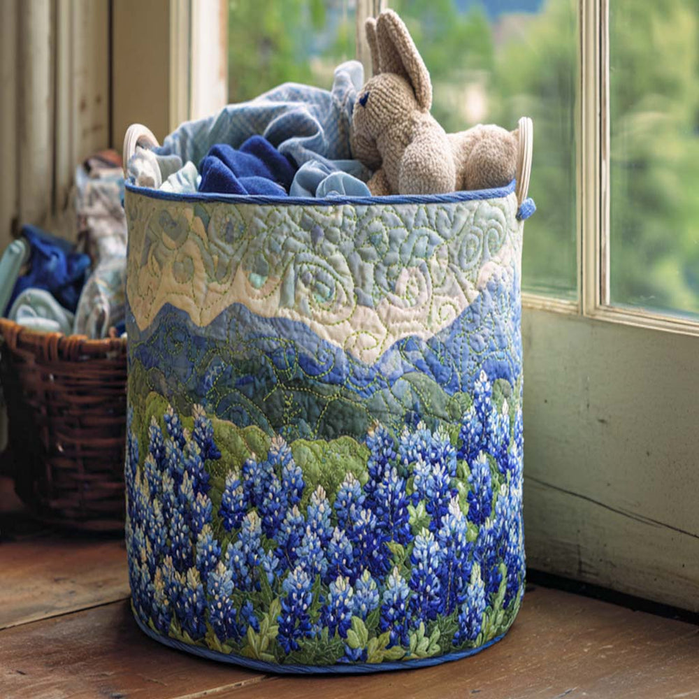 Tecla hand-quilted laundry basket with a field of blue lupins beneath rolling blue hills, front view