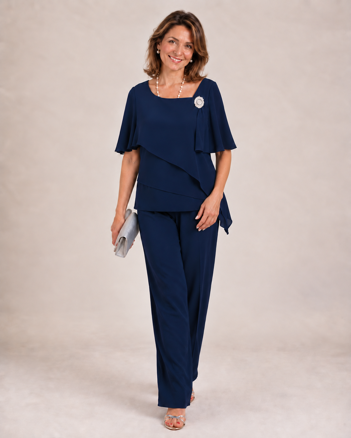 Becky layered top and trouser set in navy blue, front view with clutch