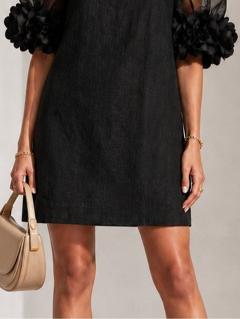 Minette puff-sleeve mini dress in black, hem detail view