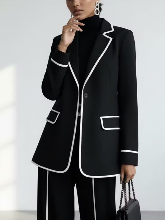 Claudia contrast-piped trouser suit in black, close-up of single-button blazer with white piping