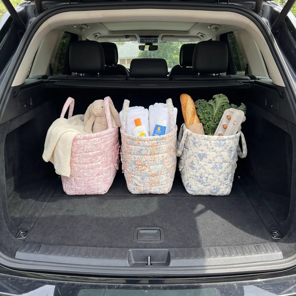 Hettie quilted everything basket in Spooky Bloom, in a car boot with several baskets