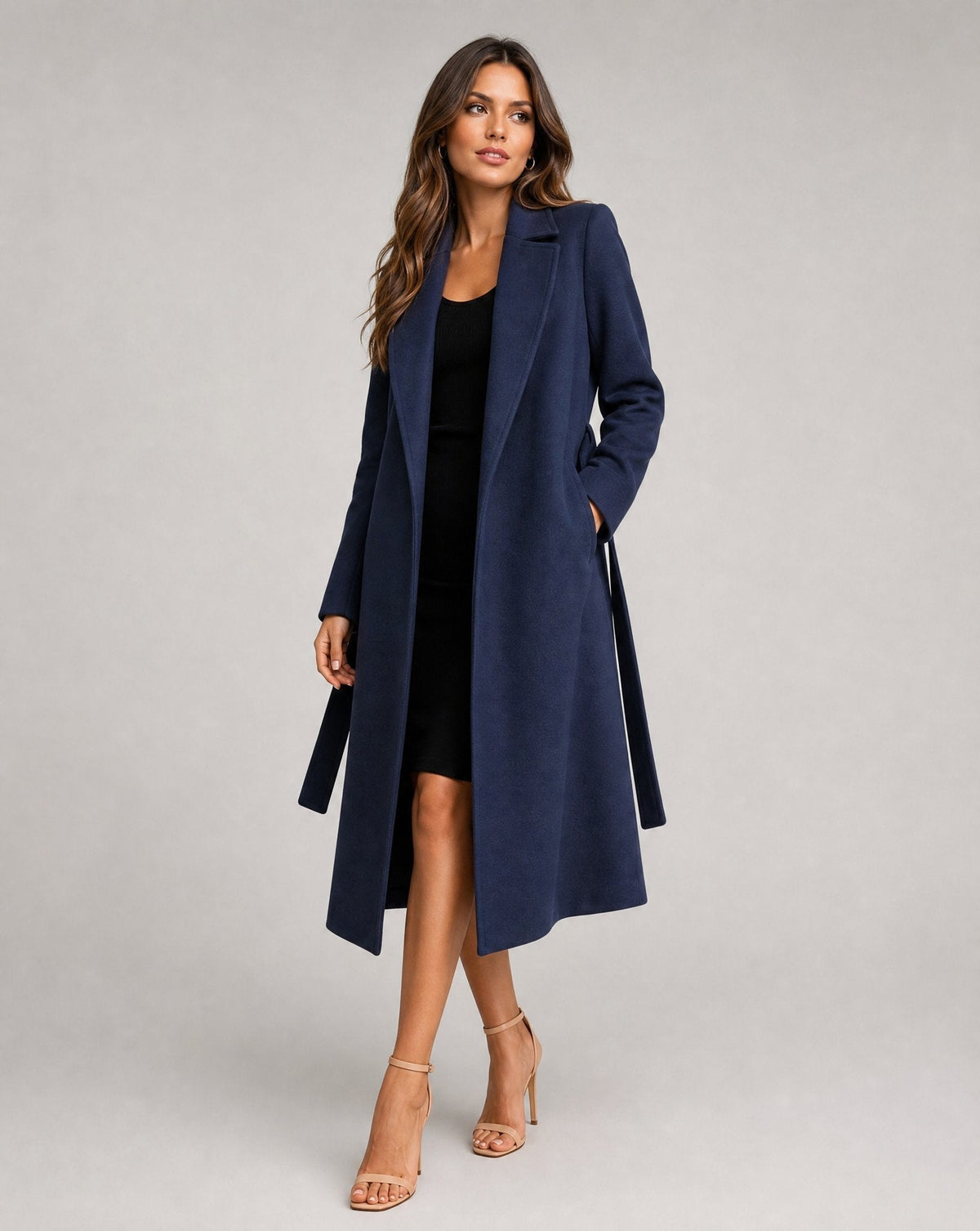 Josie long belted lapel coat in navy, full-length view over a black dress
