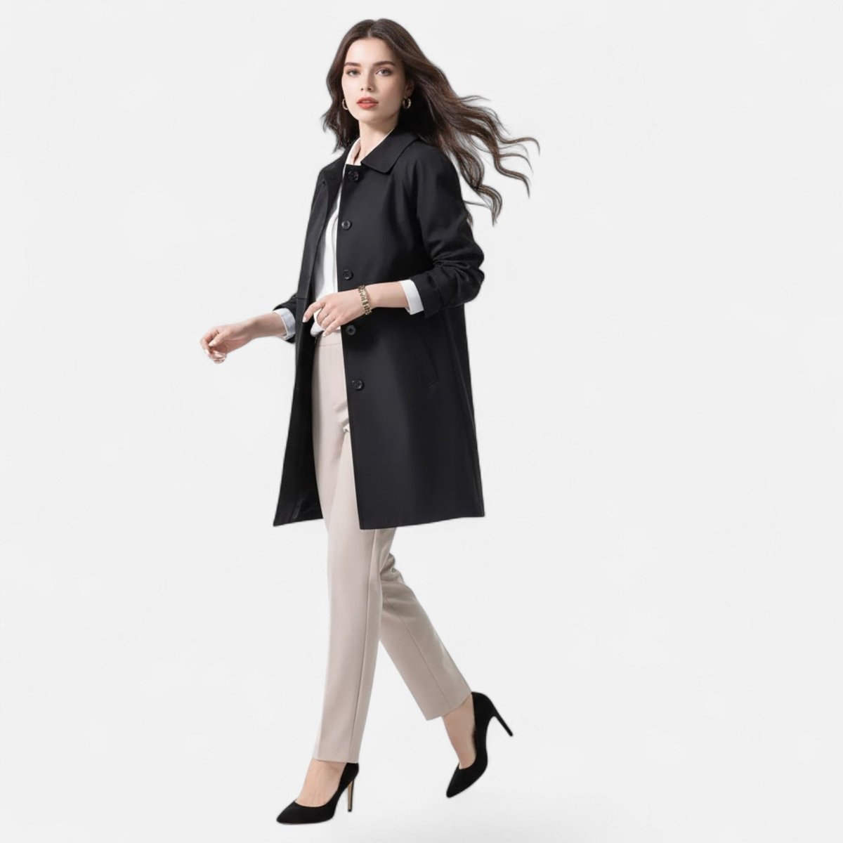 Margery tailored mid-length coat in black, worn over cream trousers, walking view